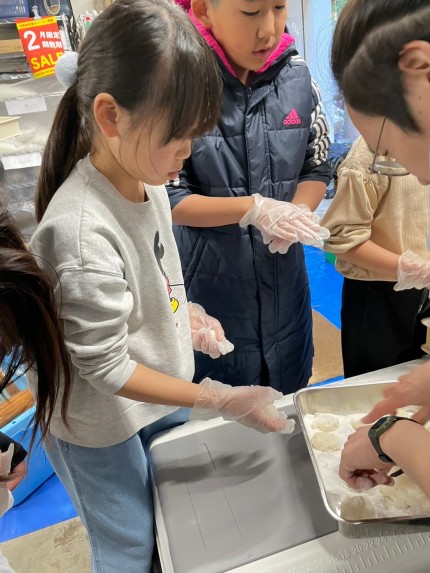 つきたてのお餅を丁寧に丸める子どもたち