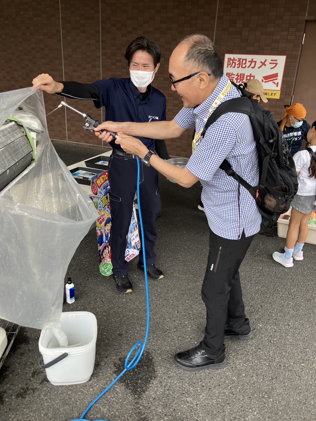 スタッフのサポートを受けながら、エアコンの高圧洗浄を体験